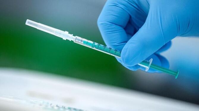 Ein Mitarbeiter eines Impfzentrums hält eine Spritze in der Hand Ein Mitarbeiter eines Impfzentrums hält eine Spritze in der Hand