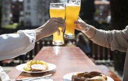 Zwei Menschen sitzen bei gutem Wetter in einem Biergarten