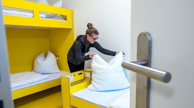 Eine Mitarbeiterin der neuen Jugendherberge richtet in einem Gästezimmer des modernen Hauses die Betten.