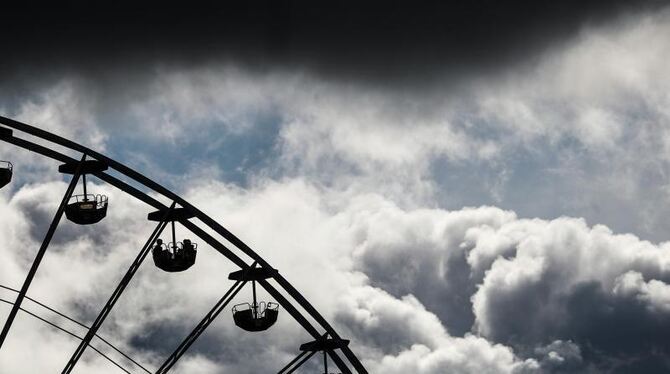 Dunkle Wolken ziehen hinter einem Riesenrad vorbei Dunkle Wolken ziehen hinter einem Riesenrad vorbei