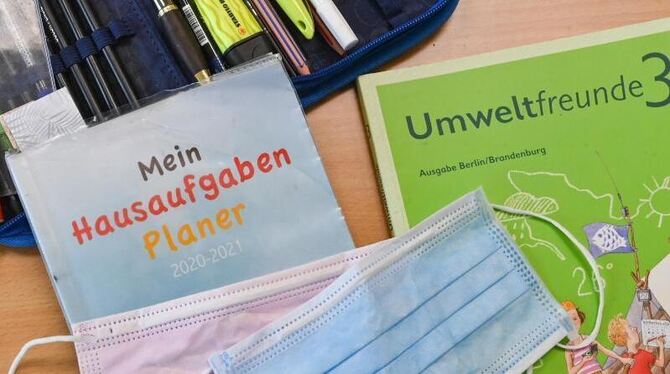 Masken liegen auf Arbeitsmaterialien eines Schülers Masken liegen auf Arbeitsmaterialien eines Schülers