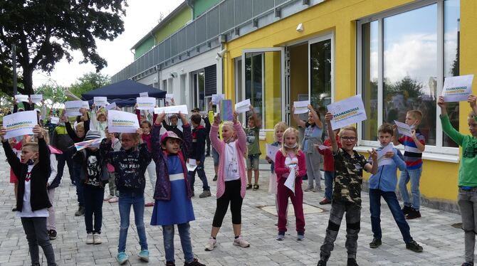 Grundschüler der Rulamanschule Grabenstetten halten stolz Schilder mit den neuen Schul-Logos hoch.  FOTO: SANDER