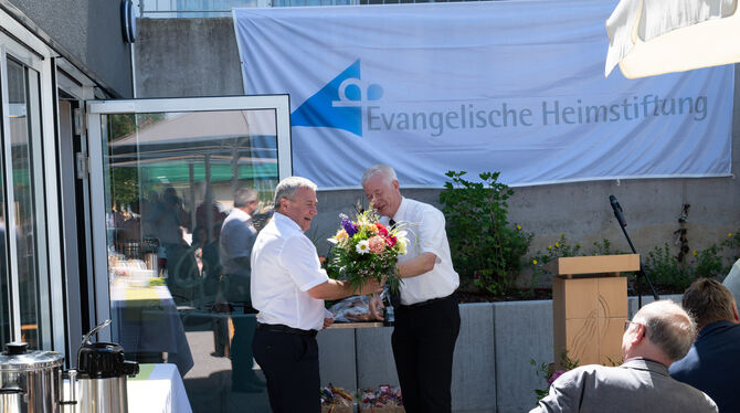 Peter Hettig, Prokurist der Evangelischen Heimstiftung (rechts), übergibt Hausdirektor Johann Eichinger zum Dank für zehnjährige