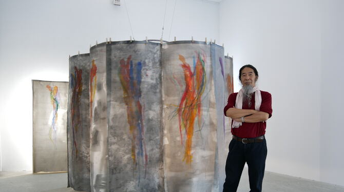 Koho Mori-Newton steht vor seinem  »Jellyfish-Karussell«, an dem sich seidene  Stoffbahnen um ein Licht im Innenraum der Konstru