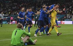 Gegensätze: Die Italiener feiern den Titelgewinn, Englands Keeper Jordan Pickford am Boden. FOTO: POTTS/DPA