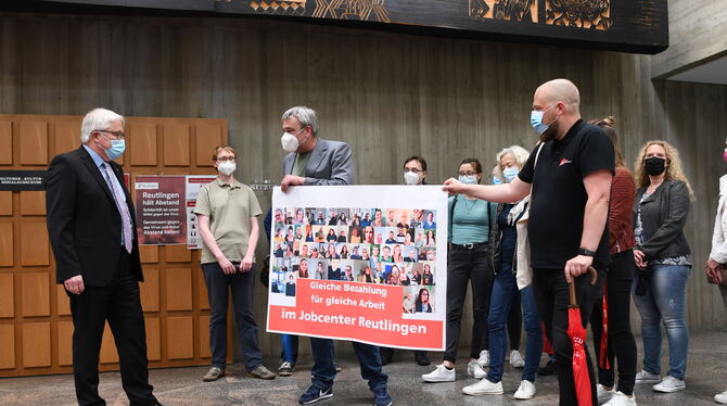 Reutlingens Verwaltungsbürgermeister Robert Hahn (links) nimmt die Petition für gleiche Bezahlung im Jobcenter entgegen.  FOTO: