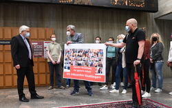 Reutlingens Verwaltungsbürgermeister Robert Hahn (links) nimmt die Petition für gleiche Bezahlung im Jobcenter entgegen.  FOTO: 