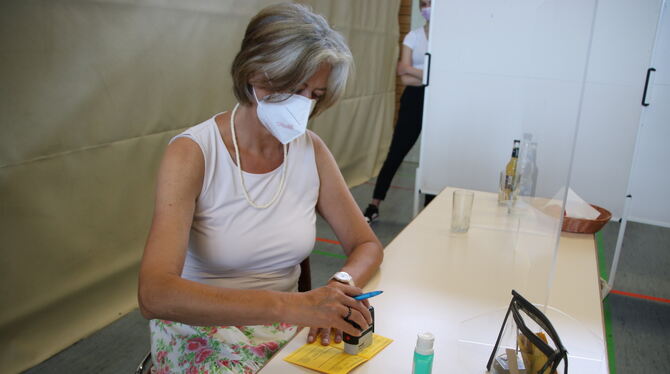 Dr. Gabriele Weiß stempelt bei der vorerst letzten Impfaktion in der Ermstalhalle in Bad Urach einen Impfausweis ab.  FOTO: OECH