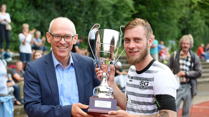 Uwe Weber (links) von der Stadt Reutlingen überreicht Christian Locher, dem Kapitän und Torjäger der SG Reutlingen, den Siegerpo