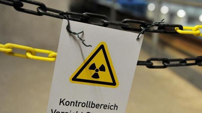 Ein an einer Kette befestigtes Schild warnt vor Strahlung im atomaren Zwischenlager in Gorleben. Foto: Jochen Lübke/Archiv