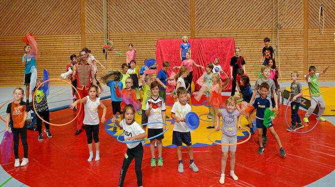 Kinder des Mitmachzirkus mit Profi Manuel Späth während der Proben auf dem roten Manegeteppich.  FOTOS: NIETHAMMER