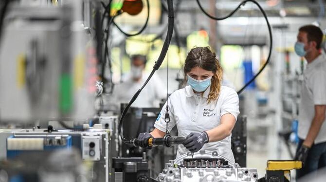 Eine Monteurin arbeitet im Werk an ein Getriebe für Lastwagen.