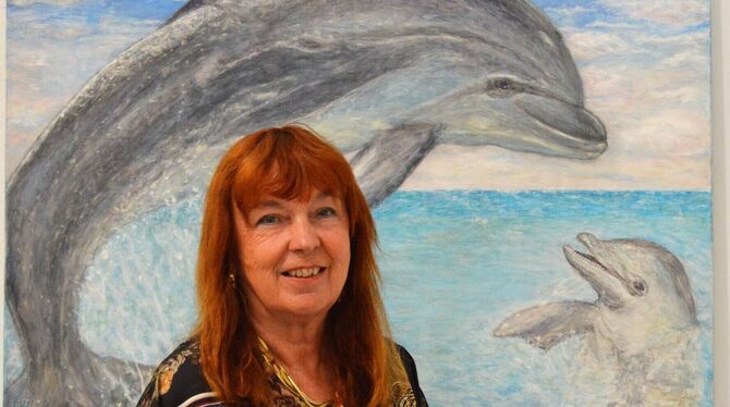 Connie Hasenclever vor einem Delfinbild in ihrer Ausstellung in Tübingen