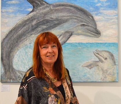 Connie Hasenclever vor einem Delfinbild in ihrer Ausstellung in Tübingen