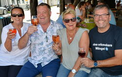 Besucher des Weinkulturtags auf dem Metzinger Kelternplatz prosten sich zu.