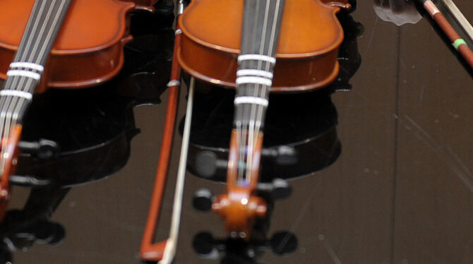 Zwei Geigen liegen auf einem Tisch.