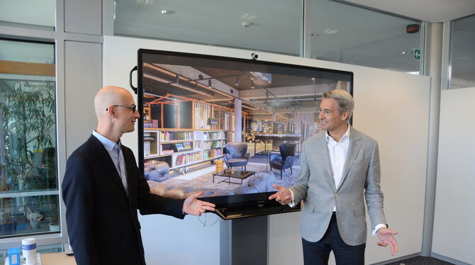 Vor der Wohnzimmeratmosphäre einer neu eingerichteten Bibliothek: der Bibliothekarische Direktor Johannes Neuer (links) und Ekz-