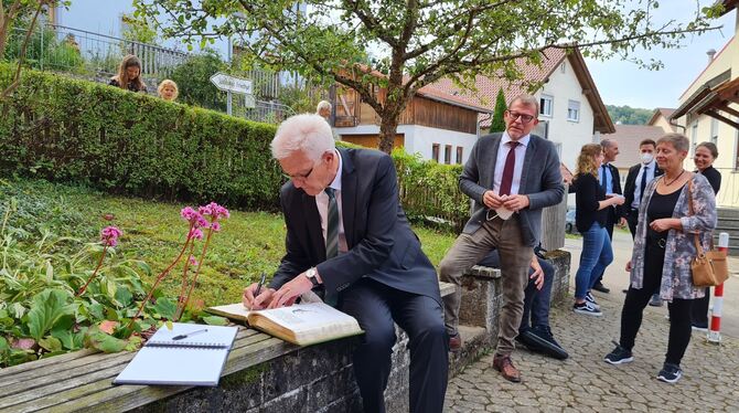 Winfried Kretschmann trägt sich ins Goldene Buch der Stadt Münsingen ein. Der Politiker Erzberger ist für ihn auch ein Beispiel