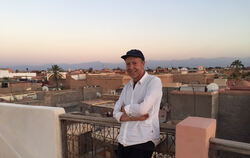 Unter sich die Altstadt von Marrakesch, am Horizont der Hohe Atlas: Der Tübinger Auswanderer Joachim Fränznick auf dem Dach sein