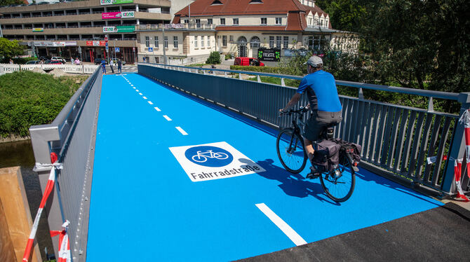 Ein Mann fährt mit seinem Fahrrad über die neu eröffnete und beheizbare Radbrücke in Tübingen. Für Lastwägen ist die Brücke alle
