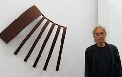 Der Nehrener Künstler Jochen Warth neben einer Wandarbeit aus Stahl 