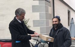 Tübingens Oberbürgermeister Boris Palmer übergibt dem Inhaber des Collegium Theo Kalaitzidis 30 Mehrwegbestecke. Das Besteck bes