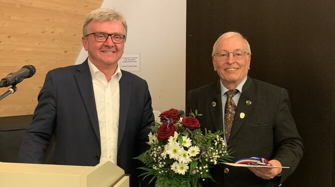 Bürgermeister Elmar Rebmann (links) überreicht Eugen Kramer, langjähriger Vorsitzender des Uracher Albvereins, für sein außergew
