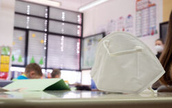 Eine FFP2-Maske liegt in einer ersten Klasse an einer Grundschule auf einem Tisch. 