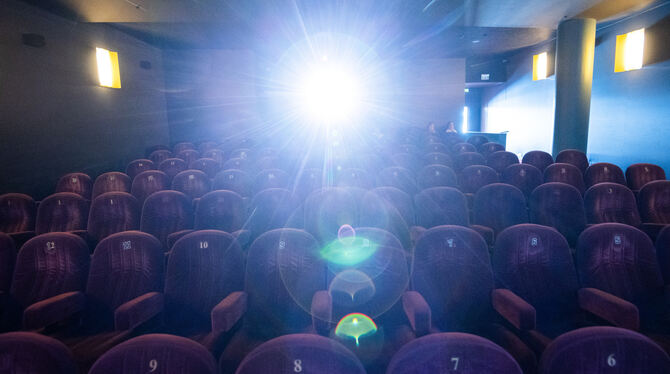 Ein Filmprojektor leuchtet in einem Kino.