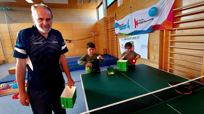 Wolfgang Dieth vom TSV Mägerkingen zeigt den Kindern, wie man Tischtennis spielt.  FOTO: FISCHER