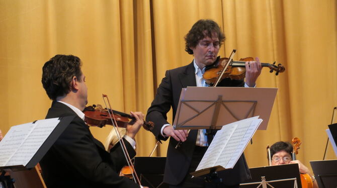 Stefan Knote als Solist an der Geige und Dirigent beim Konzert des Martinskollegiums in den Pfullinger Hallen.  FOTO: KNAUER