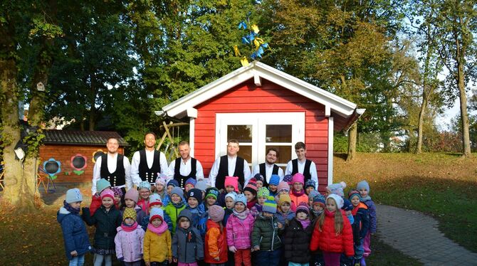 Vollbrachtes Werk: Die Mädchen und Jungen aus dem Kindergarten Pfronstetten freuen sich über das Gartenhaus, das die Zimmerer-Az
