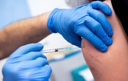 Ein Klinikmitarbeiter wird von einem Kollegen gegen Corona geimpft. In Metzingen gibt es diese Möglichkeit in einem Impfbus und 