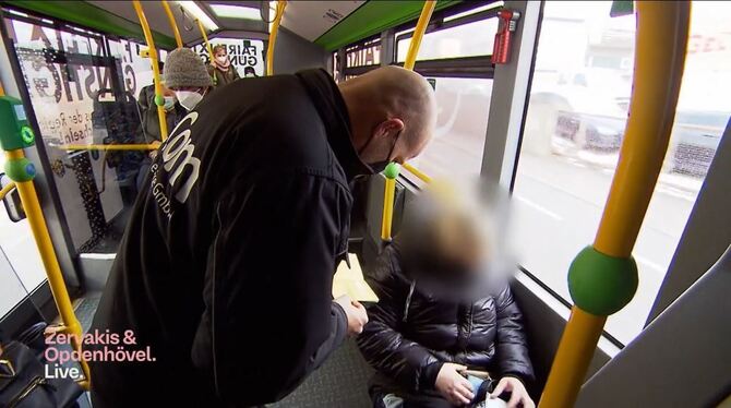 Security-Mitarbeiter Timo Linsenmayr kontrolliert den 3G-Nachweis einer Frau in einem Reutlinger Bus.