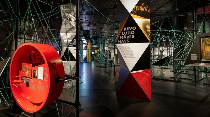 Blick in die Ausstellung mit dem charakteristischen Netz aus Nylonseilen. Im Vordergrund eines der rot umrandeten Hoffnungsfelde Blick in die Ausstellung mit dem charakteristischen Netz aus Nylonseilen. Im Vordergrund eines der rot umrandeten Hoffnungsfelde