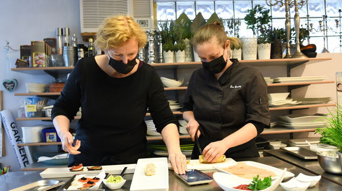 Susanne Küchler (links) und Ina Grünberg bereiten Lachspfannkuchen zu.