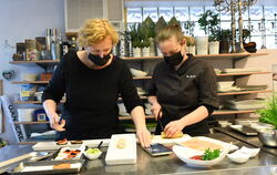 Susanne Küchler (links) und Ina Grünberg bereiten Lachspfannkuchen zu.