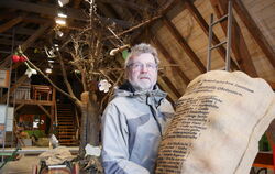 Willy Müller ist der Vorsitzende des  Fördervereins Obstbaumuseum Glems. Er hält einen Sack, auf dem bekannte Kirschensorten not