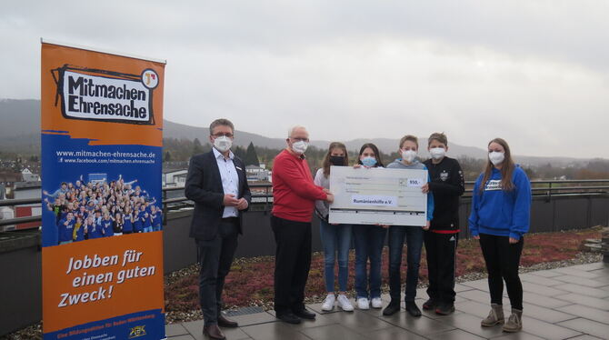 Jugendliche übergeben auf dem Dach des Mössinger Rathauses Siegfried Schanz von der Rumänienhilfe eine Spende, die sie bei der A