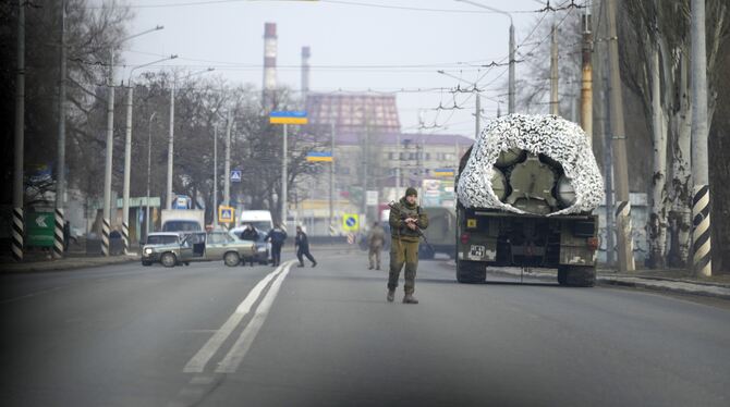 Ein ukrainischer Soldat steht auf einer Straße neben einem Militärfahrzeug in der ostukrainischen Stadt Kramatosrk. Russische Tr
