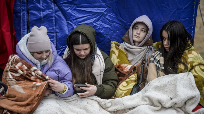 Flüchtlinge, die vor dem Krieg aus der Ukraine geflohen sind, warten an der rumänisch-ukrainischen Grenze. FOTO: DOBRE/AP/DPA