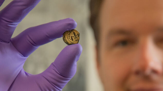 Professor Stefan Krmnicek präsentiert eine der 394 jüdischen Münzen.  FOTO: UNI TÜBINGEN