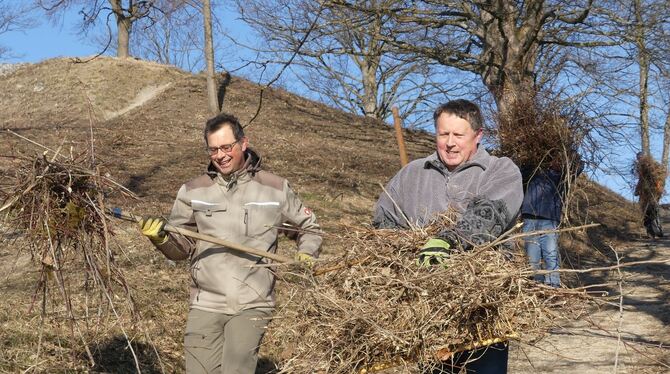 Michael Hauser (links) und Eckart Ruopp vom Metzinger Albverein tragen das am Florians-Gipfel zusammengeharkte Schnittgut in Büs