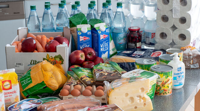 Lebensmittel und Produkte des täglichen Bedarf liegen auf einem Küchentisch in einem Privathaus.