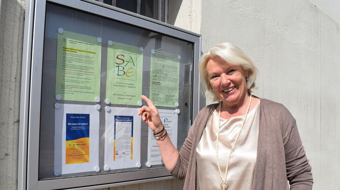 Birgit Romanowicz von der SABE weist auf die Informationen der Anlaufstelle im Schaukasten am Alten Rathaus in Kusterdingen hin.