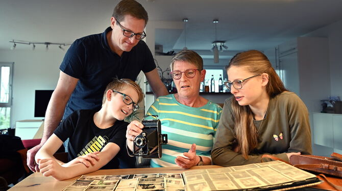 Familie Vohrer aus Pfullingen betrachtet einen alten Fotoapparat.