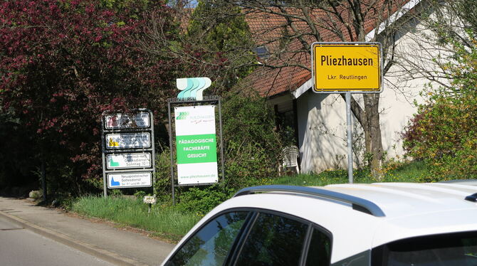 Hinter dem Ortsschild von Pliezhausen in der Bachstraße steht ein Hinweisschild, dass die Gemeinde pädagogische Fachkräfte sucht