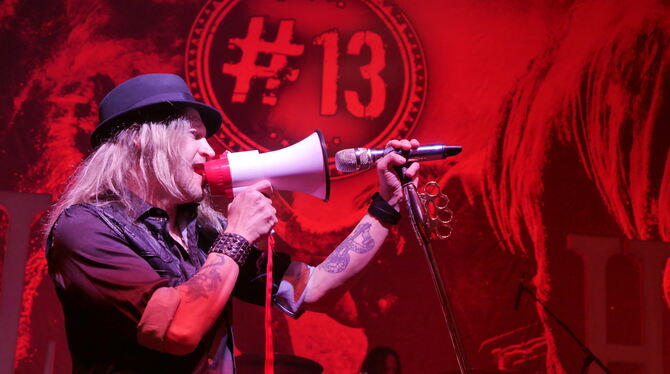 Mit einem Hilfsmittel wie auf einer Demonstration: Sänger Nic Maeder von der Band Gotthard. FOTO: MORAWITZKY Mit einem Hilfsmittel wie auf einer Demonstration: Sänger Nic Maeder von der Band Gotthard. FOTO: MORAWITZKY