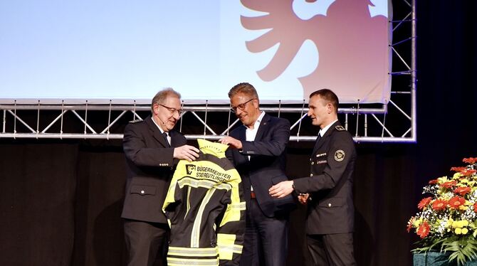 Finanzbürgermeister Roland Wintzen (Mitte) wird von Andreas Spahlinger (links) und Michael Reitter in der Feuerwehrfamilie aufg