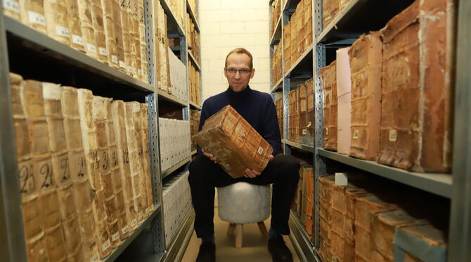 Hier atmet die Pfullinger Geschichte: Stefan Spiller sitzt zwischen den ältesten Bänden im Bestand des Archivs.  FOTOS: REISNER